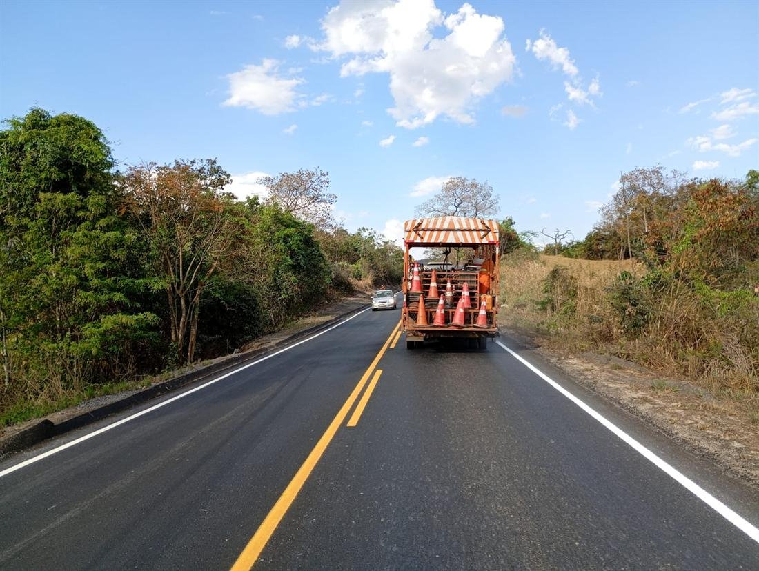 Caminhão de sinalização em serviço na pista, carregado de cones de proteção